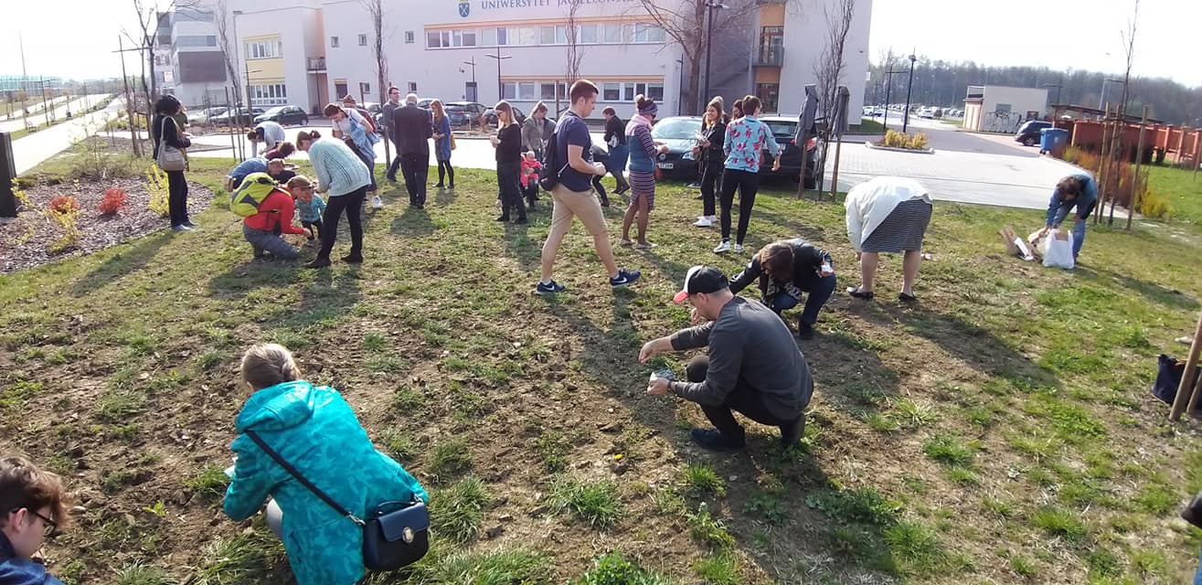 grupa ludzi sieje nasiona łąki kwietnej na terenie kampusu